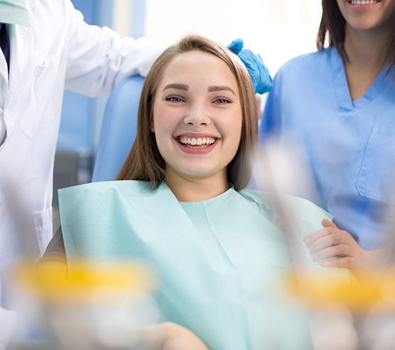 Happy patient between dental team members