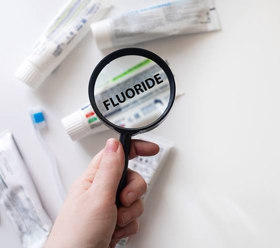 Magnifying glass showing fluoride as an ingredient in toothpaste