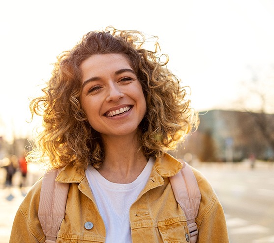 Smiling young woman standing outside