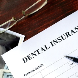 Implant and money stack representing the cost of dental implants in Owings Mills