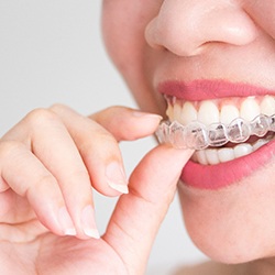 Close-up of a person putting Invisalign in Owings Mills, MD in their mouth