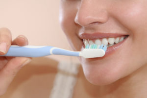 woman brushing his teeth smiling