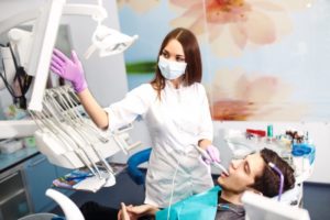 A dentist examining a patient’s mouth via an intraoral camera.