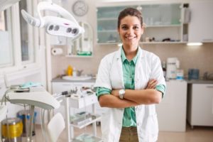 a female dentist standing with her arms folded and smiling