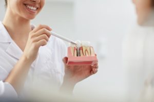 Dentist pointing to model of dental implant