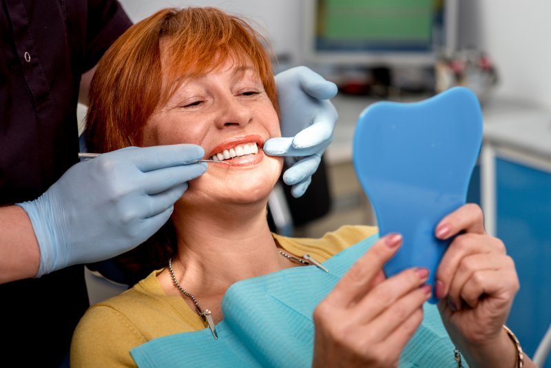 A woman admiring her new dentures